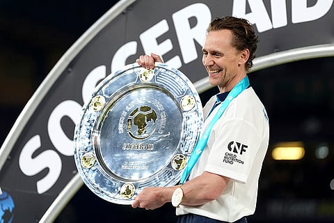 Tom Hiddleston celebrates with trophy